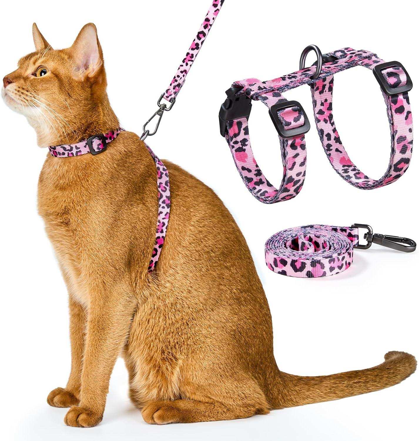 Cat wearing pink leopard print cat harness and leash set with adjustable straps and 360-degree swivel clasp on white background