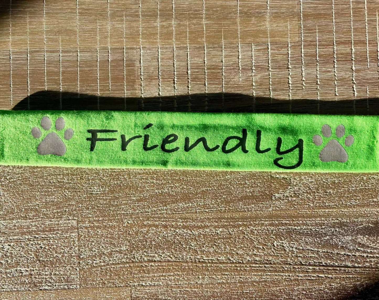 Green reflective lead slip for dogs with "Friendly" text and paw prints for safety and communication