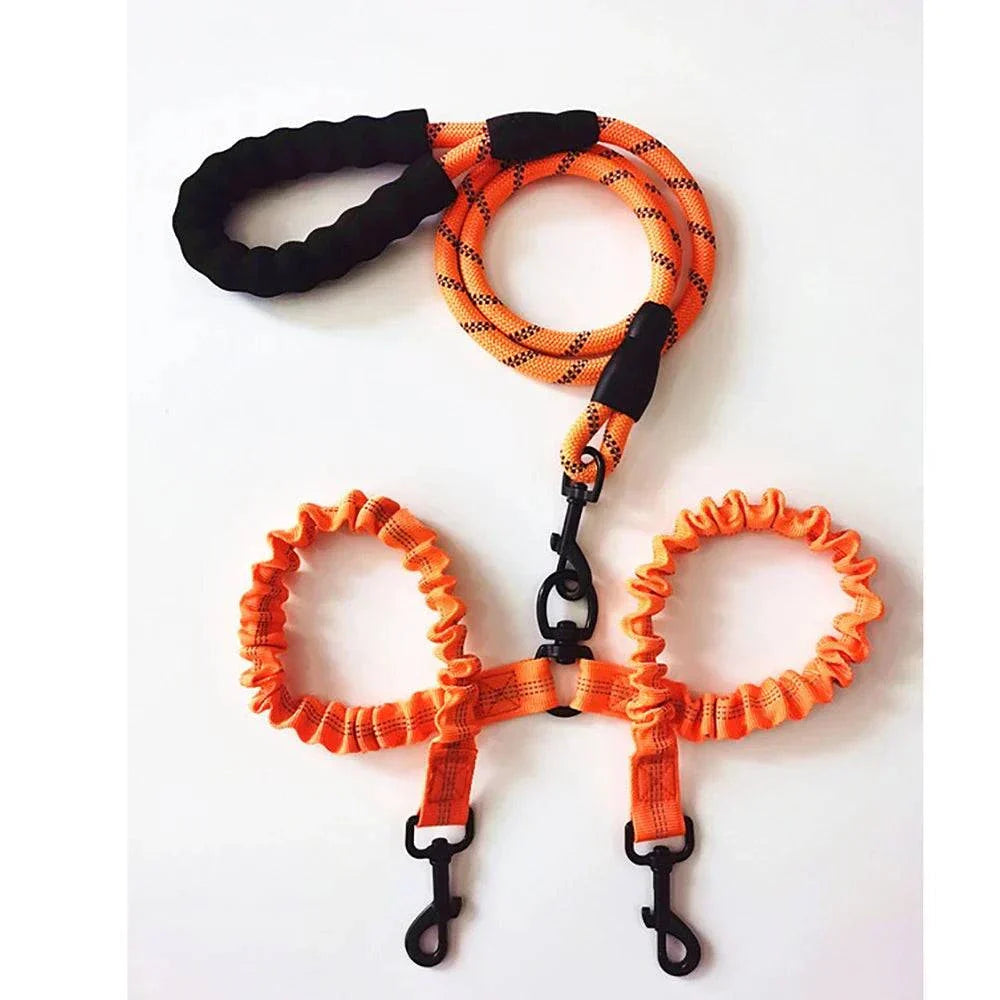 Orange dual bungee rope leash for walking two dogs with padded handle and swivel clasps