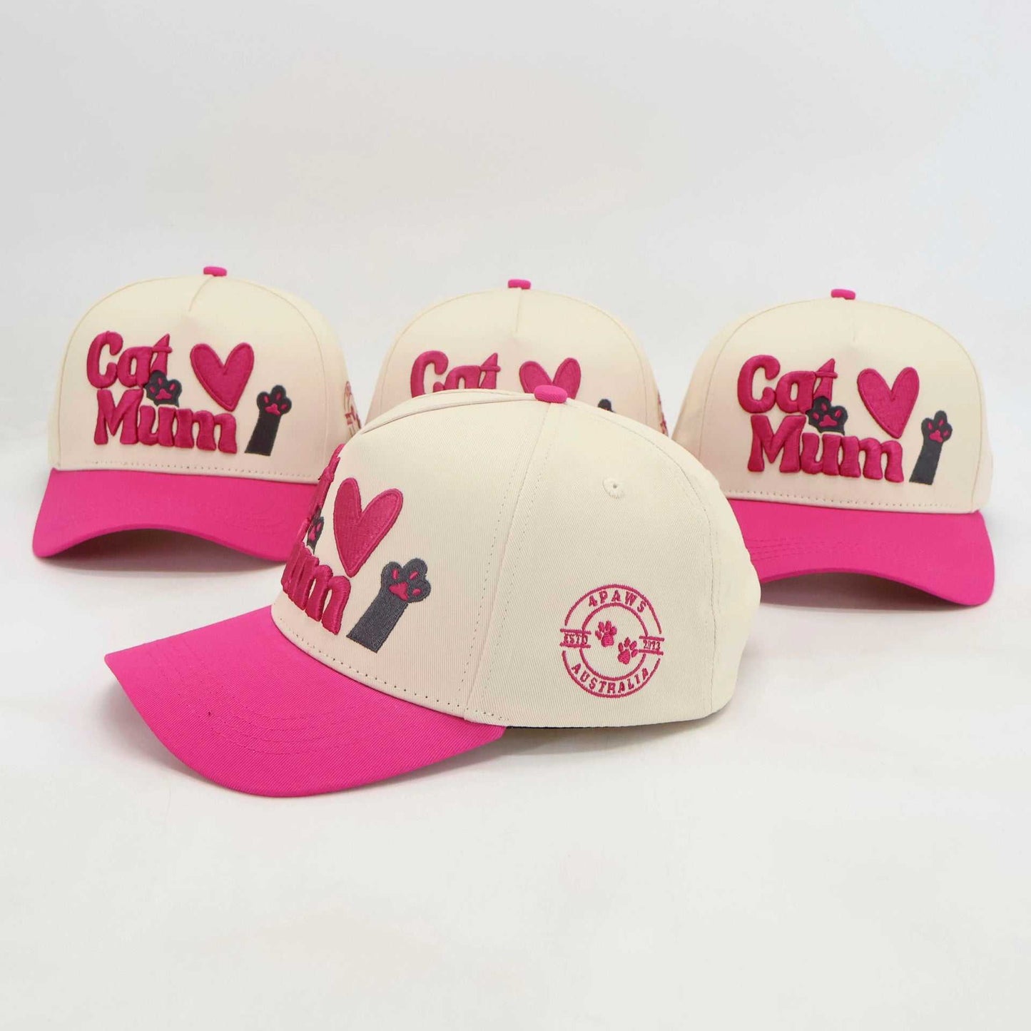 Pink and cream embroidered baseball hats with "Cat Mum" text and paw design