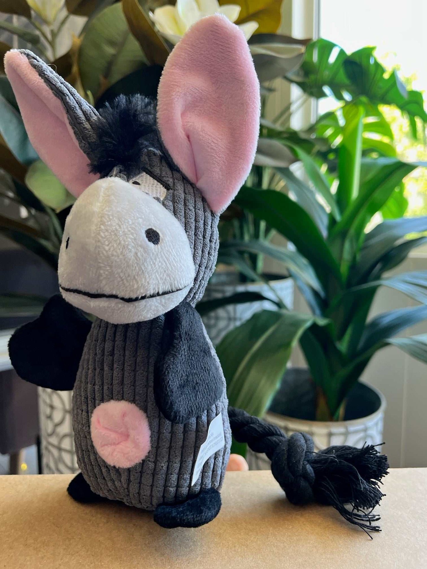 Interactive plush donkey dog toy with squeaker, crinkle ears, and rope tail for dental care