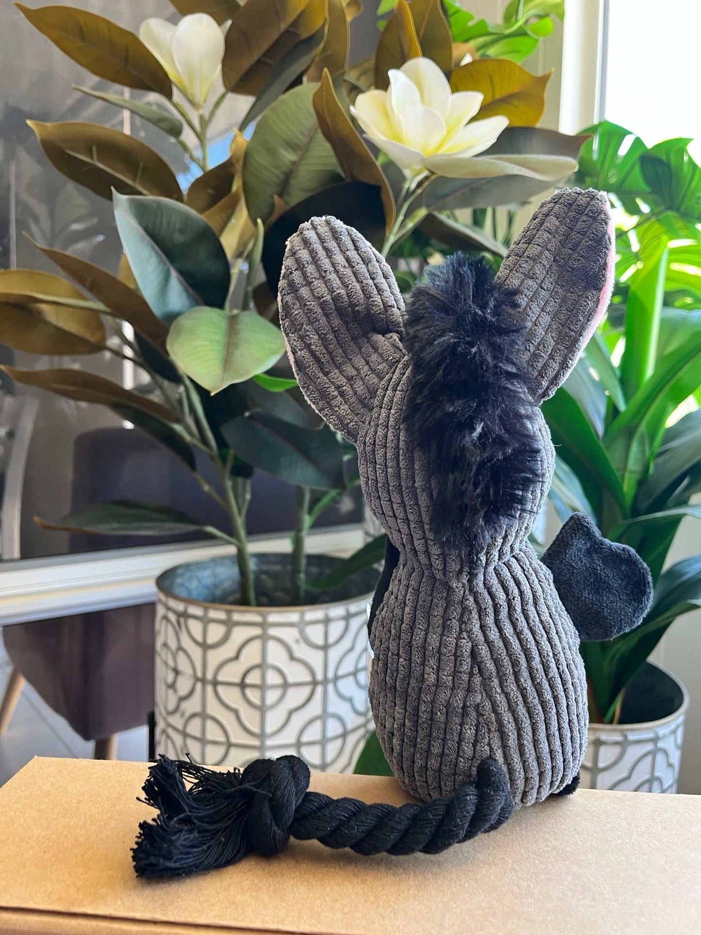 Interactive plush dog toy donkey with squeaker, crinkle ears, and rope tail for dental care, designed for small to medium dogs.