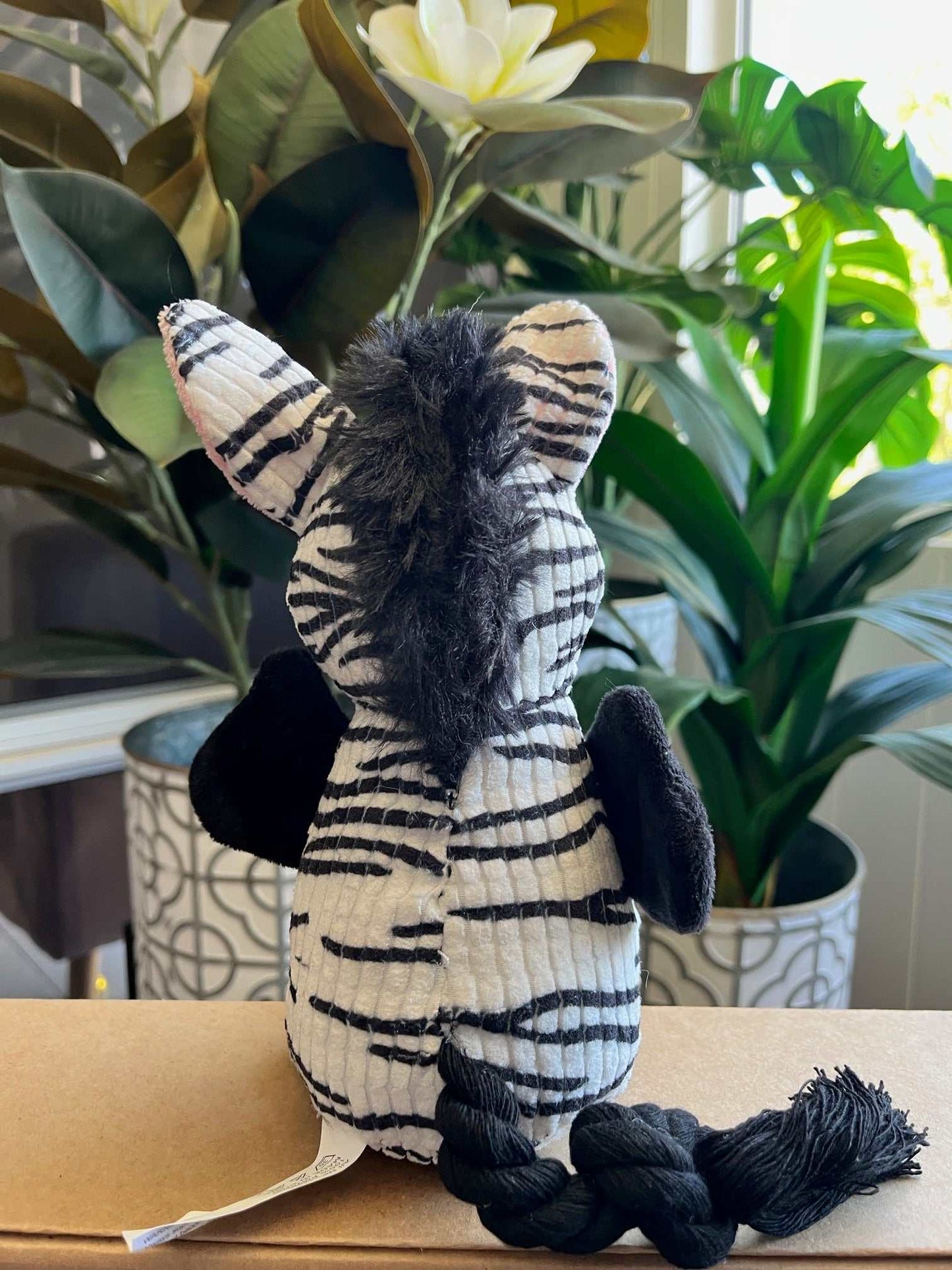 Interactive plush toy zebra with squeaker, crinkle ears, and rope tail for small to medium dogs.