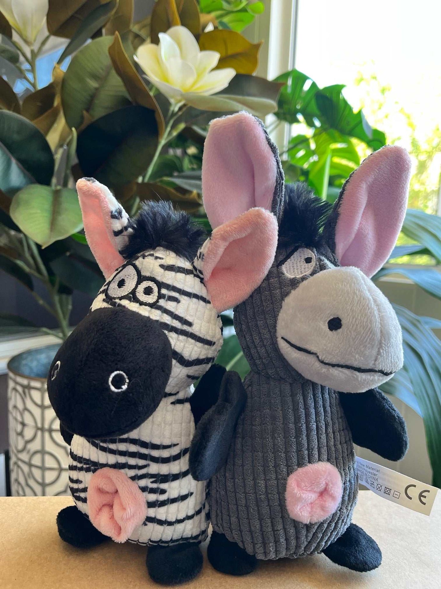 Interactive plush toy featuring donkey and zebra with squeaker, crinkle sounds, and rope tail for small to medium dogs