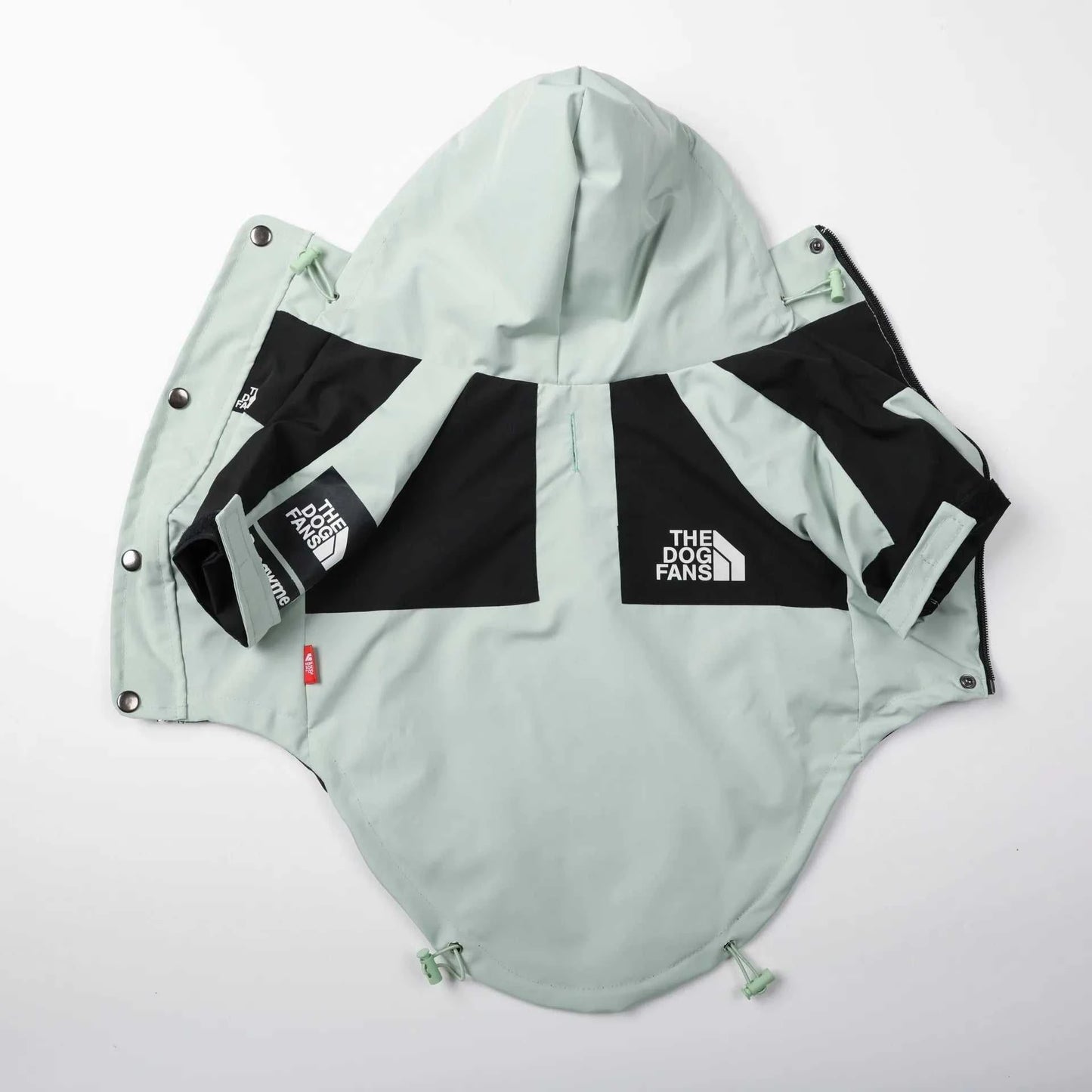 Rain jacket for dogs in black and mint green, designed for protection and style during wet weather.