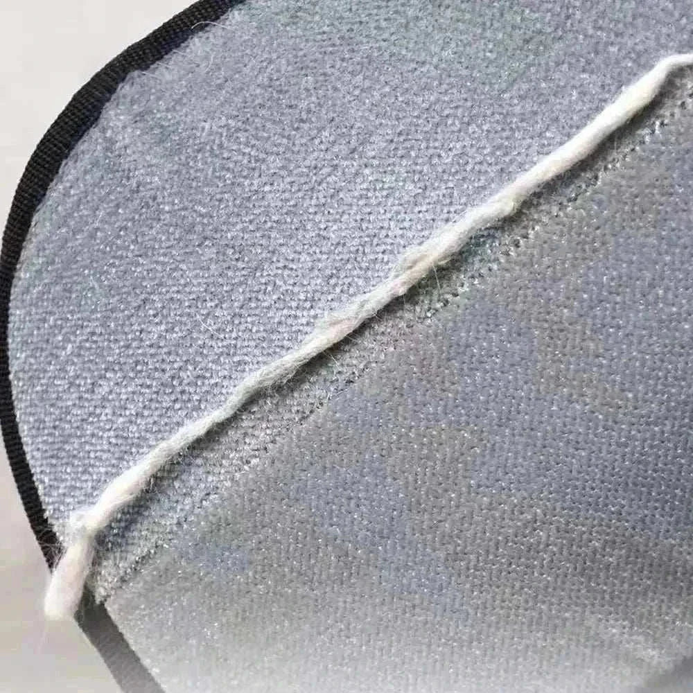 Close-up of eco-friendly Two-Way Pet Hair Removal Glove from Cat Vās Couch Defender Duo Bundle against gray couch fabric