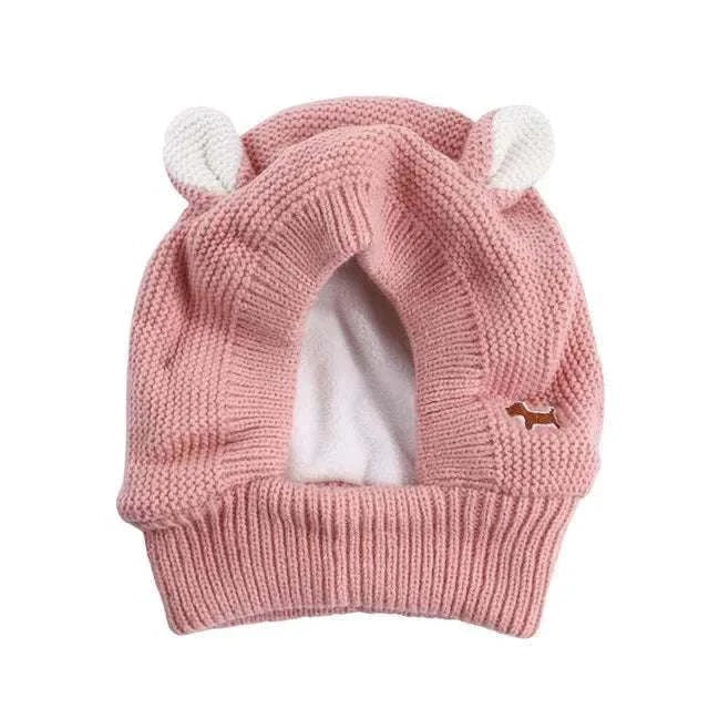 Pink knitted anxiety relief ear protection hat for dogs with white ear details and soft lining