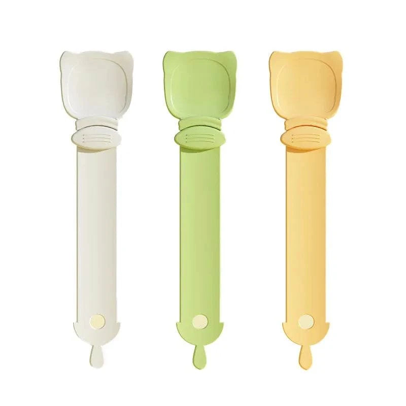 Set of three Cat Strip Spoon Feeders in white, green, and yellow with cat-ear shaped tops and ergonomic handles for safe, mess-free feeding.