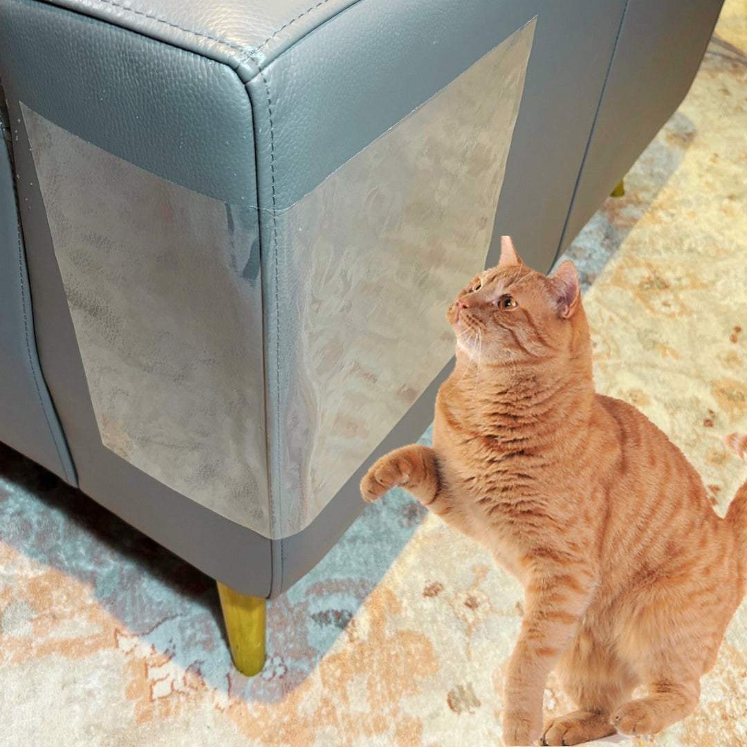 Cat V’s Couch Defender transparent cat scratch deterrent tape on blue sofa corner with orange cat pawing at it