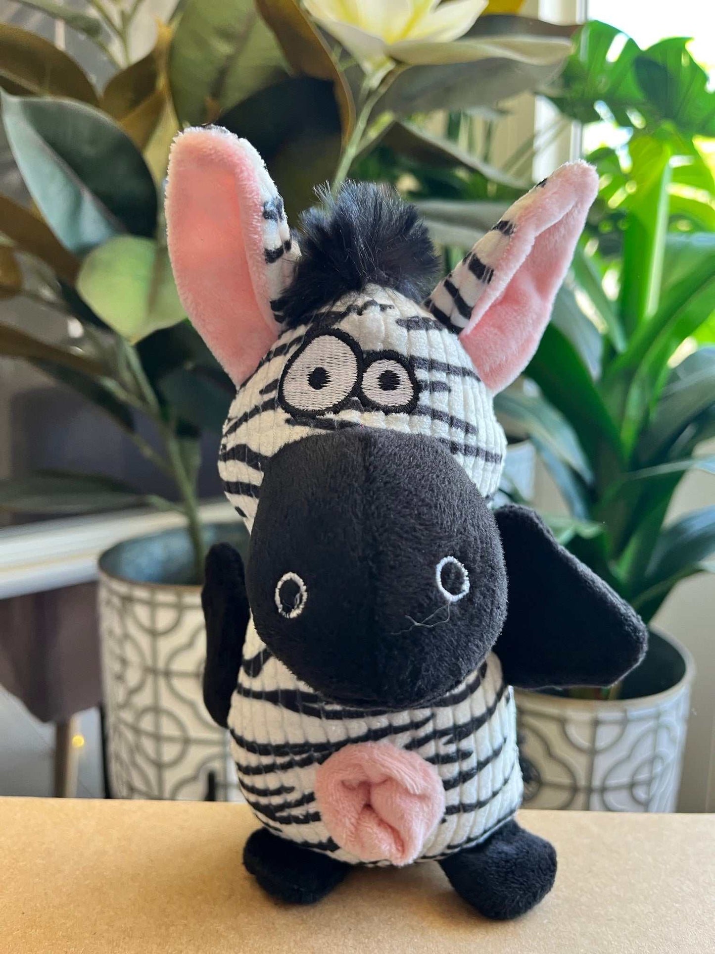 Interactive plush toy for dogs with squeaker, crinkle sounds, and rope tail; donkey and zebra design.