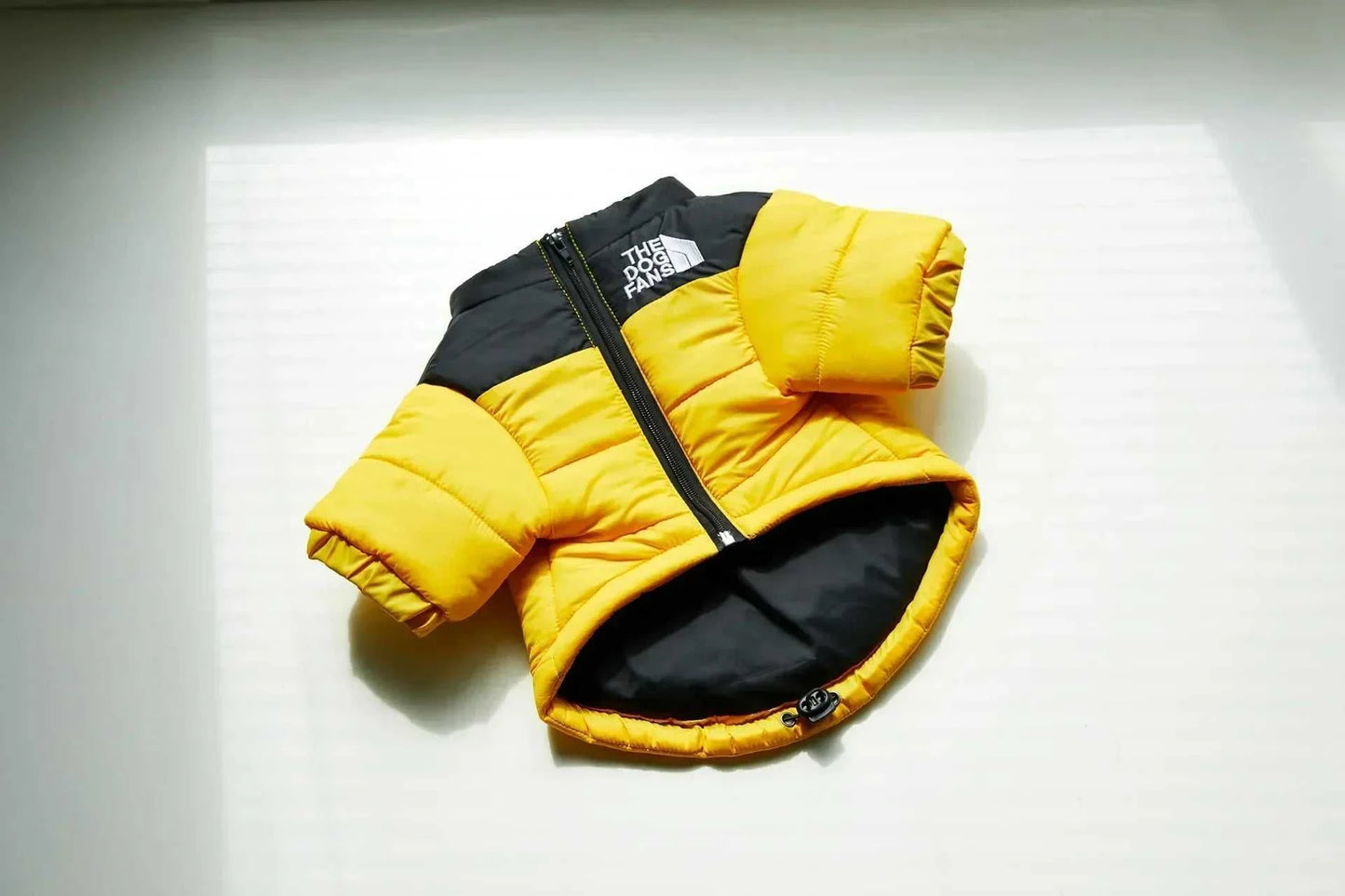 Yellow and black winter down puffer jacket for dogs, providing warmth and style.