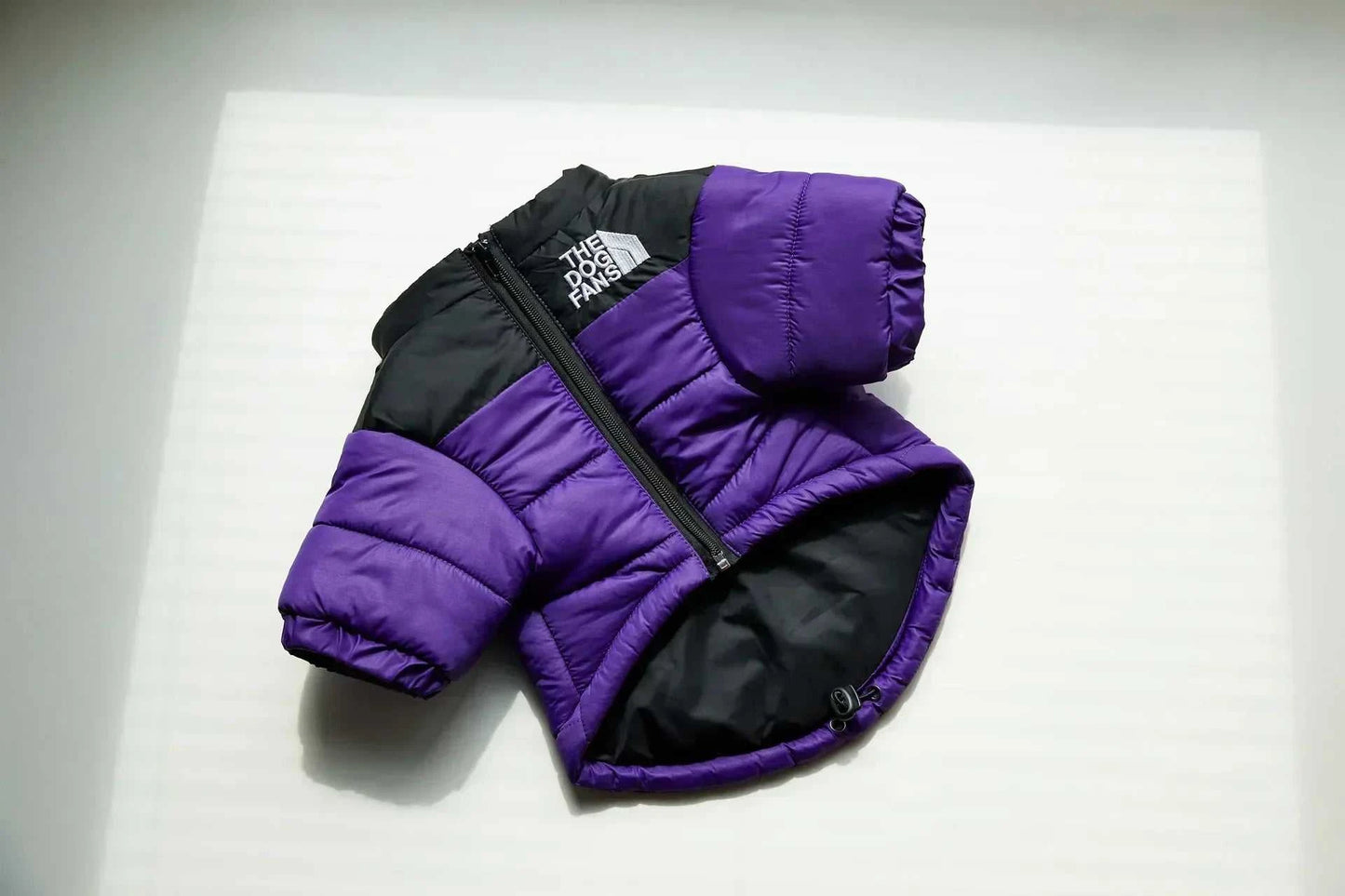 Purple and black winter down puffer jacket for dogs, designed for warmth and comfort.