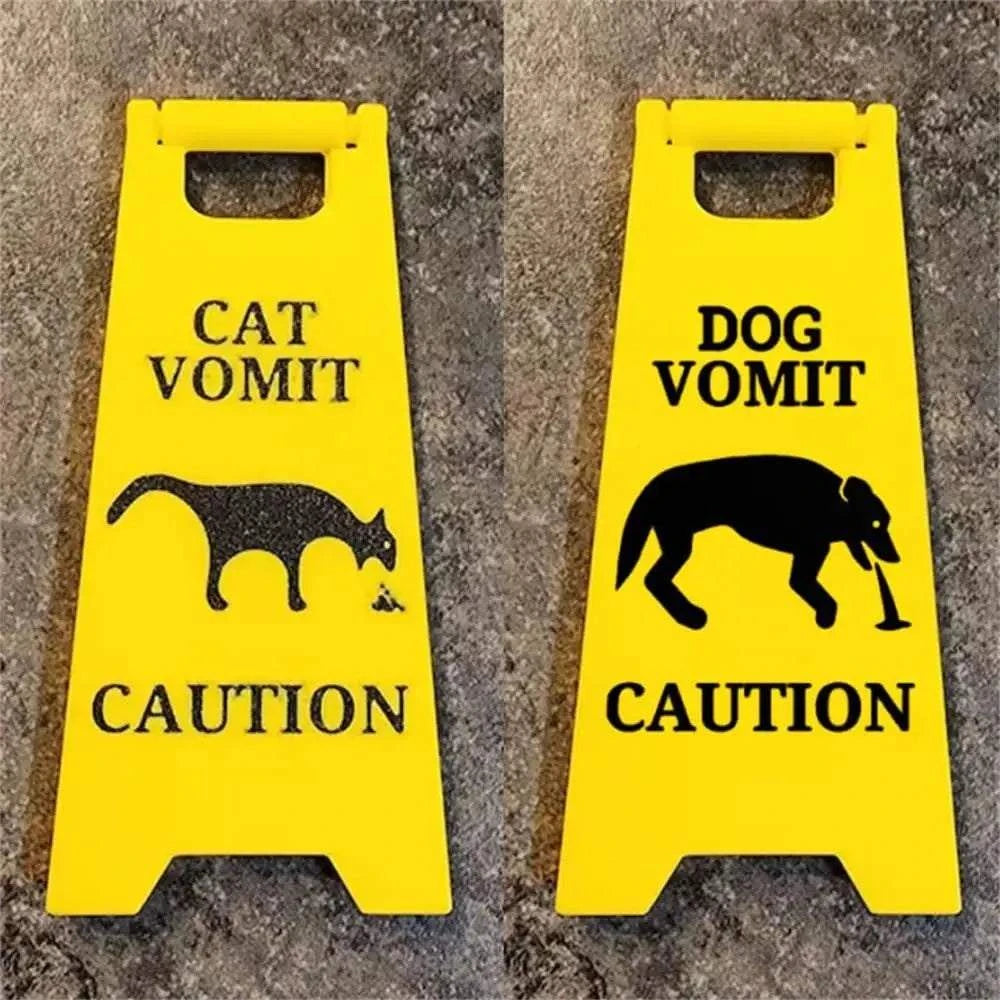 Bright yellow cat and dog vomit warning signs with black silhouettes for humorous caution.