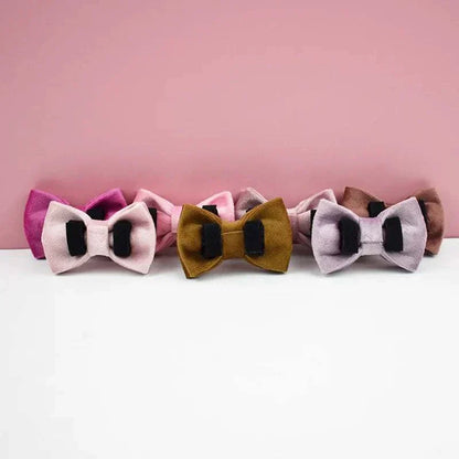 Luxury velvet cat collar with personalized engraved name plate and decorative bow ties in various colors against a pink background