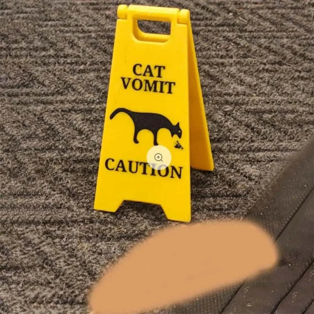 Yellow cat and dog funny warning sign featuring vomiting silhouettes on carpet.